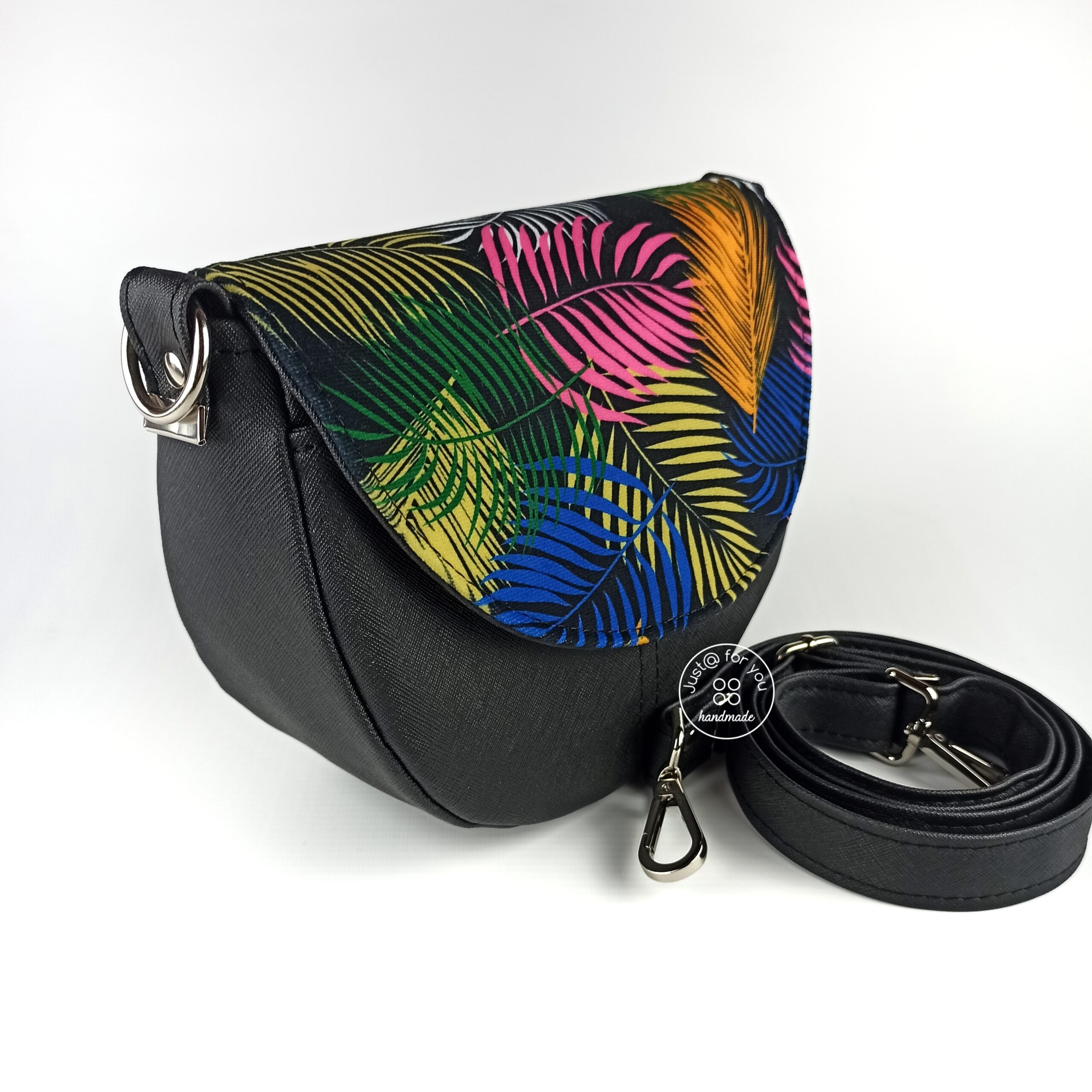 Czarna torebka na ramię z klapką z motywem kolorowych liści palmy.