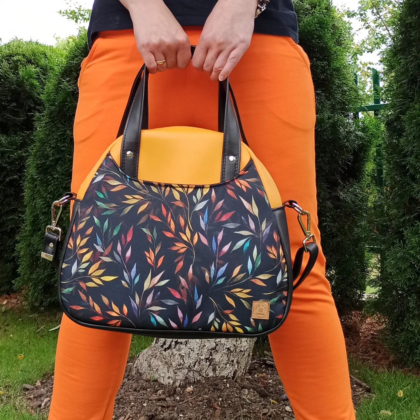 Torba damska z pomarańczowej ekoskóry oraz z kolorowym motywem liści.